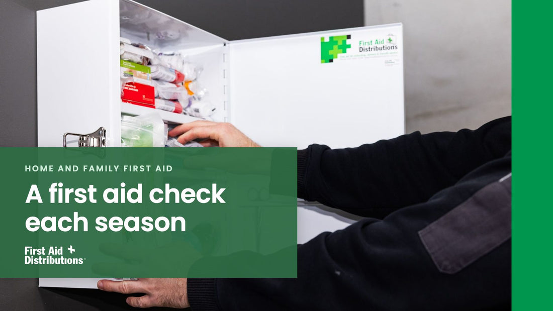 A first aid check each season: a person in a dark work jumper restocking an open wall-mounted first aid cabinet, First Aid Distributions